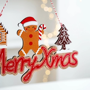 Wooden Christmas gingerbread man tree ornaments with Merry Xmas text and warm light background