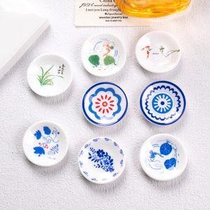 Detailed macro view of 8 miniature blue and white porcelain plates with koi and floral patterns
