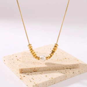 Gold plated stainless steel necklace with white pearl and hex bead accents on stone