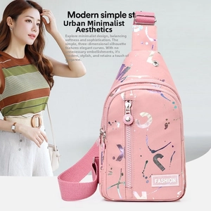 Close-up of pink crossbody bag with abstract graffiti pattern and adjustable strap