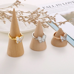 Elegante Schmetterlingsringe in Gold, Silber und Roségold mit Perlmutt auf Holzständern