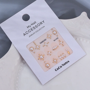 Close-up of pearl and gold star nail charms with MJ-032 retail hanging card packaging