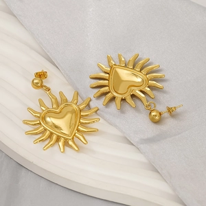 Boucles d'oreilles vintage cœur soleil dorées avec rayons sur fond de soie