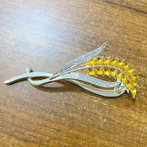Detail of wheat ear brooch with yellow crystal grains and white diamonds on silver base