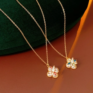 Detail von eleganten Goldblumen-Anhängern mit Perlmuttblättern und bunten Zirkoniasteinen