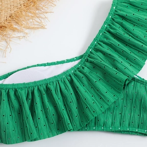 Detail of green ruffle bikini top with textured pleated fabric and cutout patterns