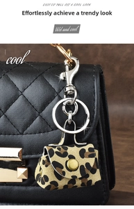 Detail of leopard print mini bag keychain with silver clasp on quilted bag