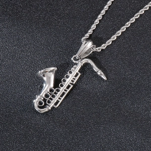 Detailed macro view of silver saxophone pendant necklace with stainless steel engraving