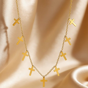 Detailed view of multiple gold cross pendants on a delicate stainless steel chain