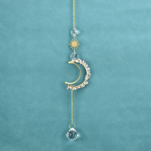 Detail of bohemian suncatcher featuring pink quartz stones and moon shaped crystals