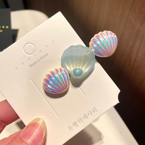 Detail view of a Korean mermaid style hair clip with iridescent shells and a center pearl