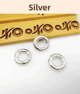 Close-up of silver-colored round spacer bead with retro embossed cloud pattern for DIY crafts