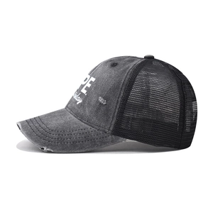 Side view of distressed grey cotton trucker hat with breathable black mesh and NOPE embroidery