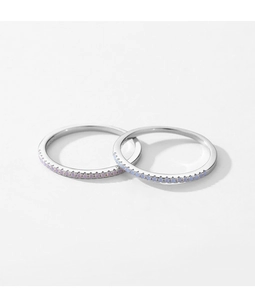 Detail of two silver S925 rings with light blue and purple crystals in a minimalist style