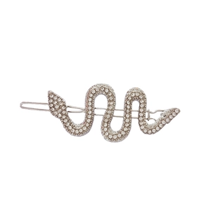 Detailed macro view of silver snake-shaped hair clip with sparkling crystal inlay