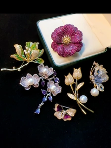 Detailed close-up of luxury floral and animal brooches with pearls and gemstones