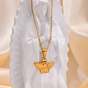 Detailed close-up of golden angel relief pendant necklace on white statue background