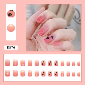 Detail of R576 short square ombre pink press-on nails with black double heart patterns