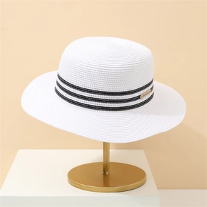 White wide brim straw sun hat with black stripe trim and gold logo for summer beach wear