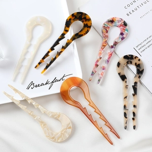Acetate U-shaped hair pins set with marble and tortoise shell patterns in a flat lay view