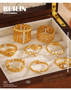 Detailed collection of gold evil eye and crown rings with zircon in a wooden jewelry box