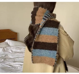 Detailed view of the soft striped knit wool scarf draped over a trench coat back