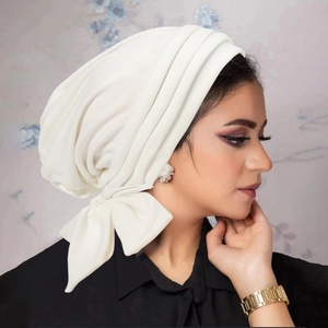 Detail of white velvet turban hat with pleated design and elegant bow decoration
