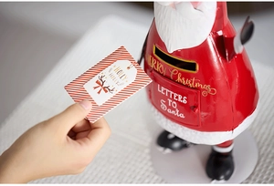 Close-up of red metal Santa mailbox with Letters to Santa engraving and festive card