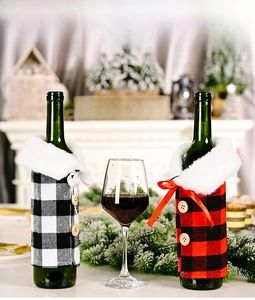 Detailed view of red and black plaid wine bottle covers with white faux fur collars