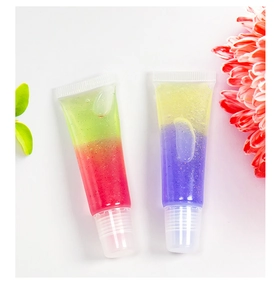 Detailed view of dual-color glitter lip gloss tubes with floral and leaf accents