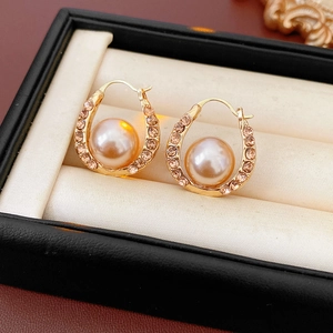 Close-up of French vintage U-shaped gold earrings with pink pearls and rhinestones