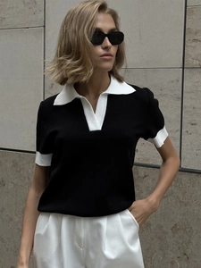 Détail du col et des poignets contrastés blancs sur le polo en maille noir pour femme