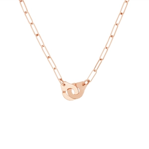 Detailed macro view of 18k rose gold handcuffs charm and paperclip chain necklace