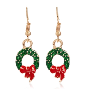 Close-up of Christmas wreath earrings with green enamel and red bow detail