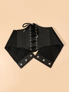 Detail of black corset belt showing metallic eyelets and criss-cross lacing on mesh fabric
