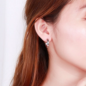 Polished silver geometric C-shape hoop earrings worn by a model for a modern look