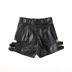 Dettaglio degli shorts neri in ecopelle a vita alta con fibbie decorative sui lati