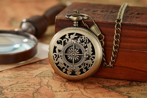 Close-up of a bronze vintage compass pocket watch cover with hollow-out adventure design