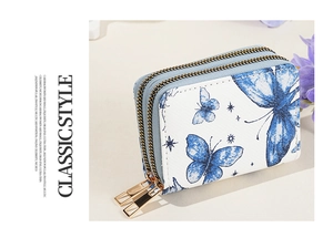 Détails de l'imprimé papillon sur un porte-cartes à double zip et ferrures dorées