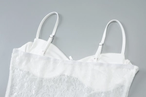 Detail of white lace camisole top with adjustable thin straps and built-in bra pads