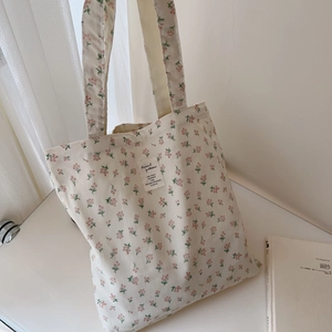Detail of floral cotton canvas tote bag featuring an artistic vintage pattern label