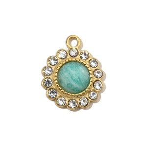 Detail of a gold plated stainless steel pendant with a green natural stone and crystals