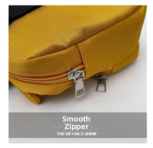 Close-up of smooth silver dual zippers and twill nylon fabric on a cute yellow handbag