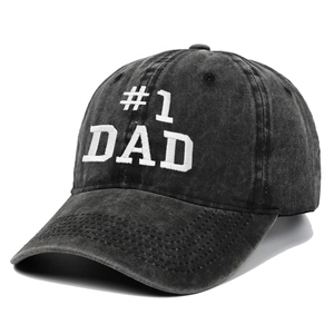 Close-up of #1 DAD white embroidery on washed black cotton baseball cap with vintage texture