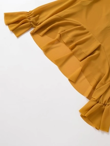Detail of ginger yellow chiffon top showing layered ruffle sleeves and hem texture