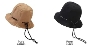 Detail of canvas bucket hats in camel and black with adjustable drawstrings and topstitching