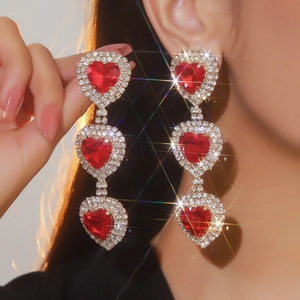 Lussuosi orecchini a cuore rosso con cristalli brillanti indossati da modella