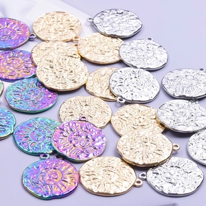 Detailed macro view of sun and moon relief coin pendants in gold, silver, and iridescent