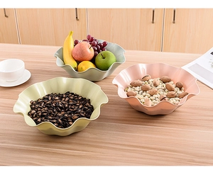 Close-up of decorative ruffled edge fruit bowls in pastel colors on a wooden table
