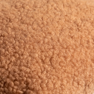 Close-up of premium brown teddy plush fabric with high-density curly fiber texture